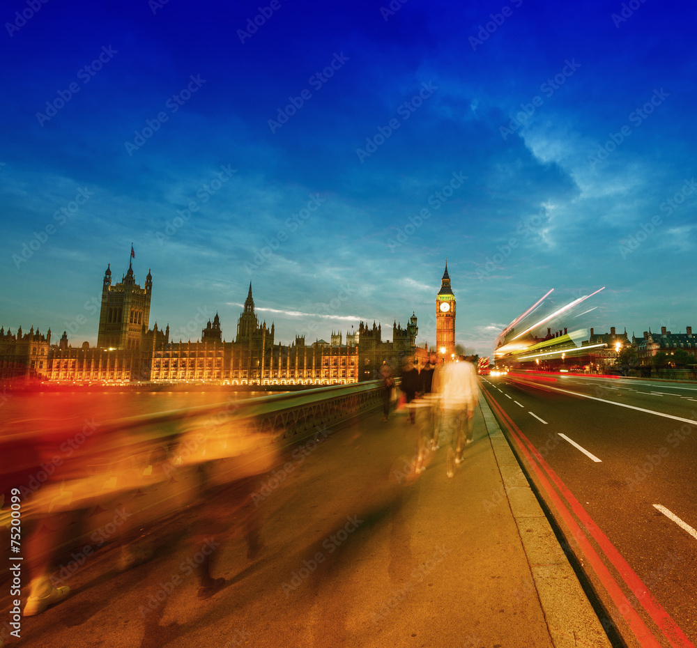 People moving on Westminster Bridge at sunset. Houses of Parliam