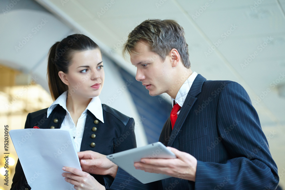 Young business woman and businessman in the hallway