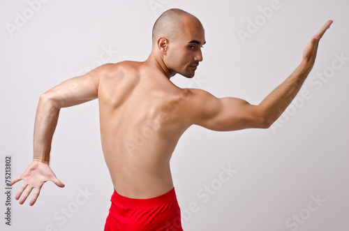 Topless dancer,fit man stripper posing with his back and arm up.