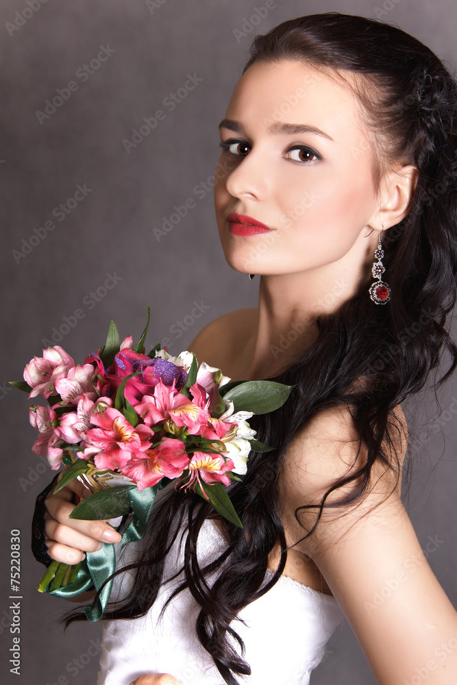 Portrait of a young beautiful fiancee with a bunch of flowers