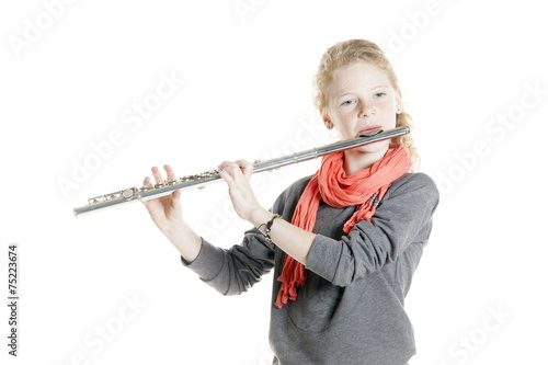 young girl with red hair and freckles plays flute photo