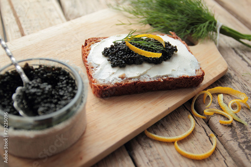 Black caviar and cream cheese on cutting bread