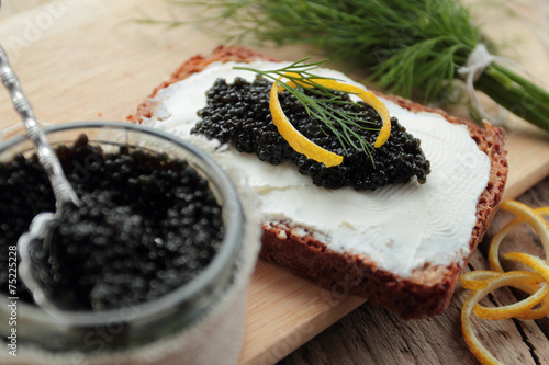 Black caviar and cream cheese on dark bread for appetizer