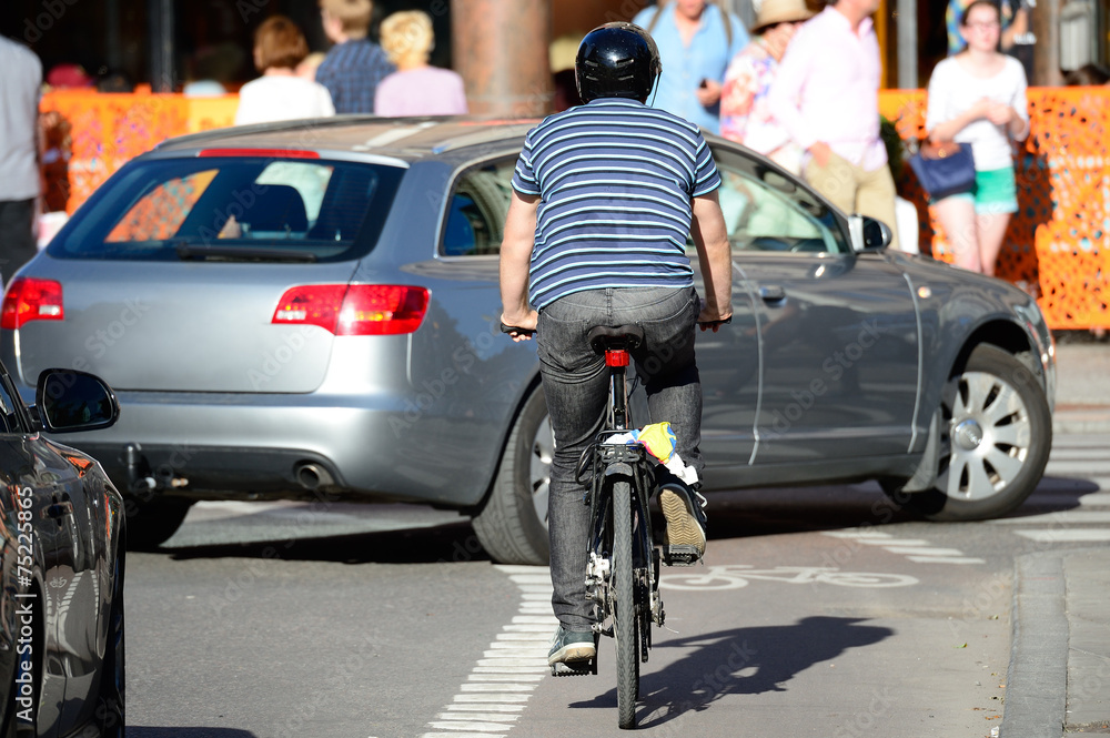 Man with helmet bicycling in traffic Man with helmet bicycling in traffic