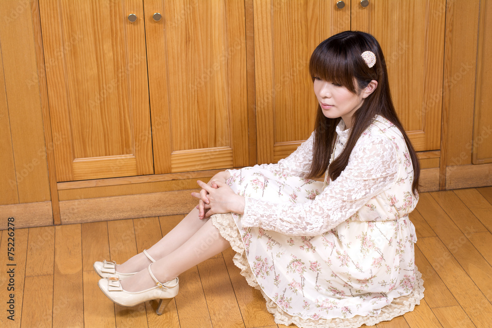 木の床に横向きに座る女性 木の床に横向きに座る女性
