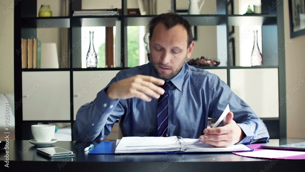 Young businessman reading and analyzing documents at home Young businessman reading and analyzing documents at home