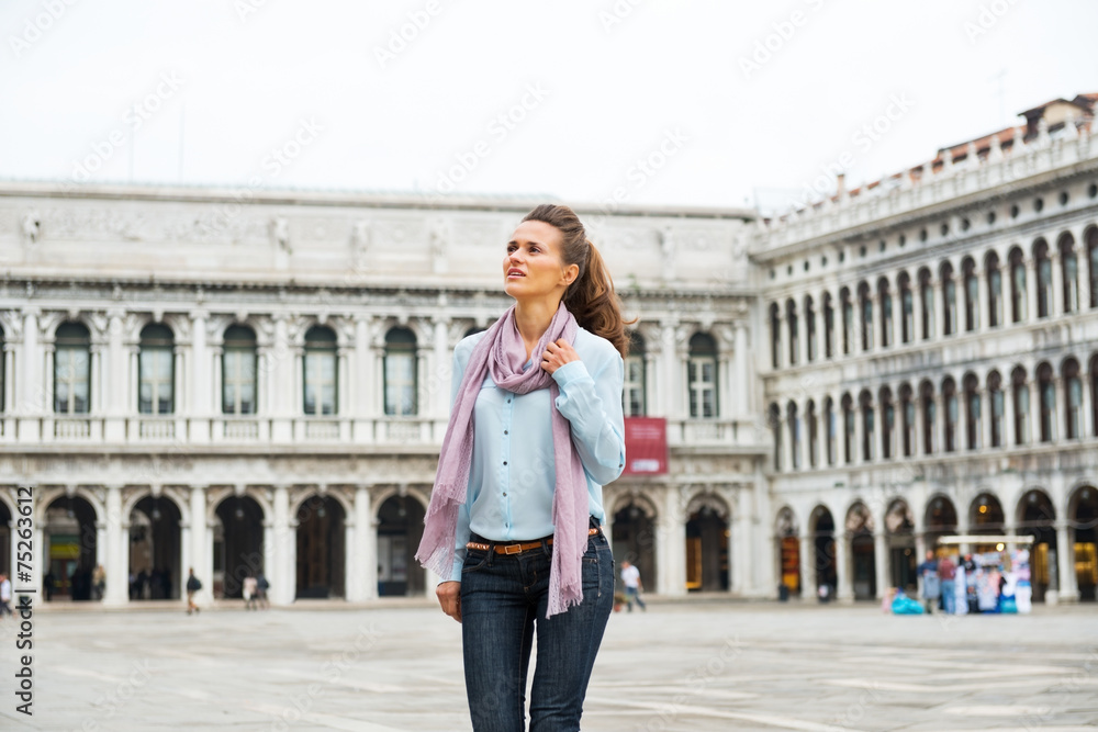 Happy young woman walking on piazza san marco in venice, italy