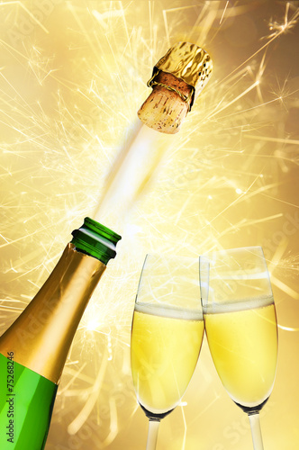 Zwei Sektgläser und Sektflasche an Silvester mit Feuerwerk