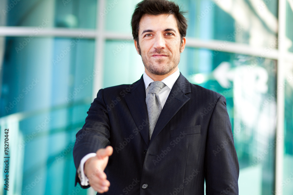 Handsome businessman giving you his hand Handsome businessman giving you his hand