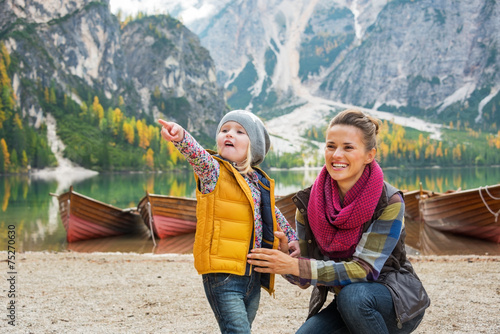 Fototapeta Mother and baby pointing while on lake braies in south tyrol