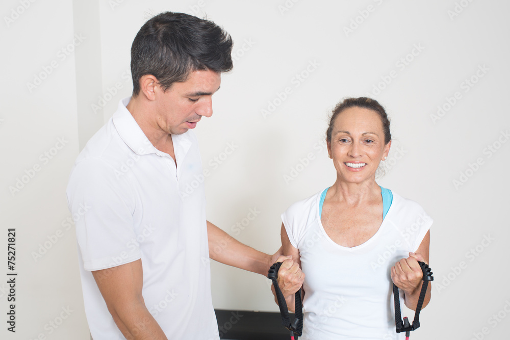 Obraz premium Trainer hilft Rentnerin mit Fitnessübung