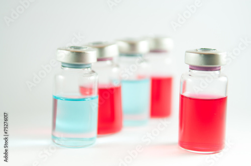 Red liquid in injection syringe and vials background