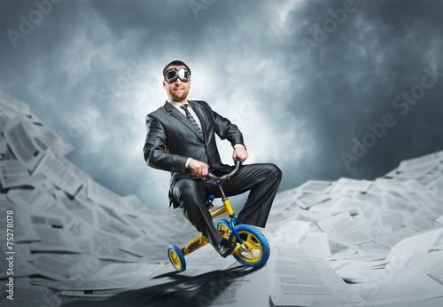 Odd businessman riding a small bicycle