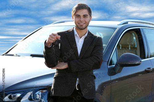 Businessman holding car key...
