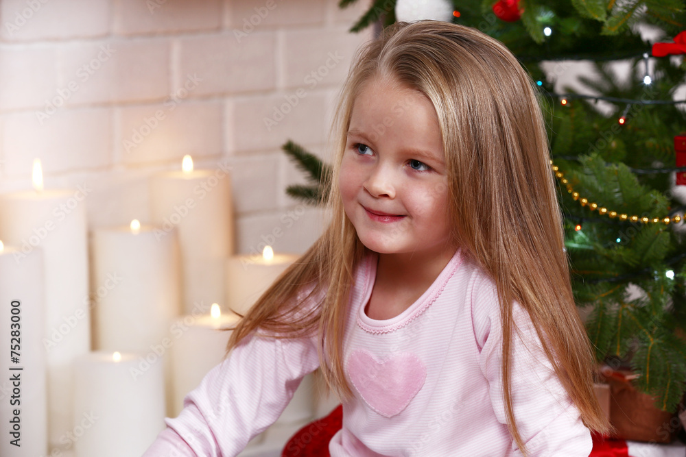 Little girl sitting near fir tree Little girl sitting near fir tree
