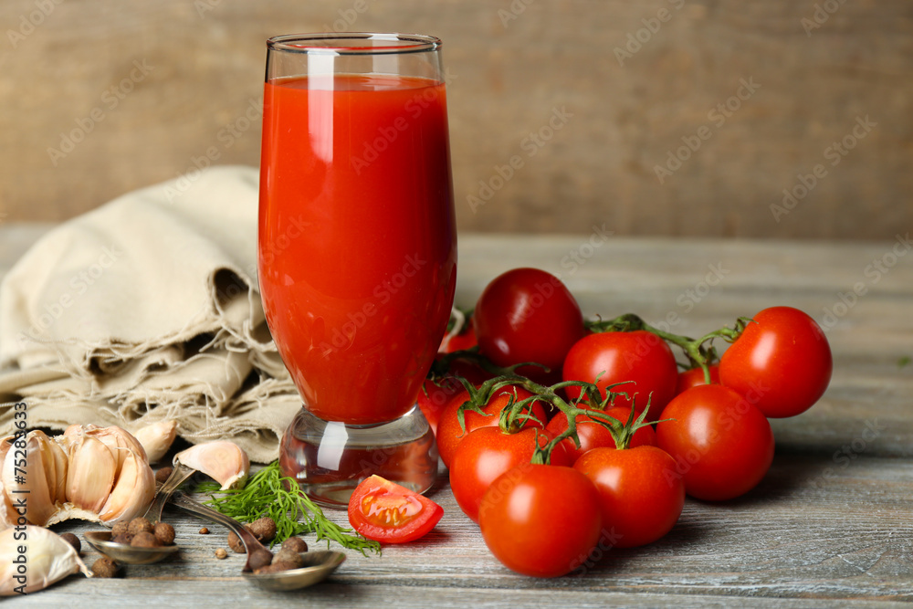 Glass of tasty tomato juice and fresh tomatoes on wooden table Glass of tasty tomato juice and fresh tomatoes on wooden table