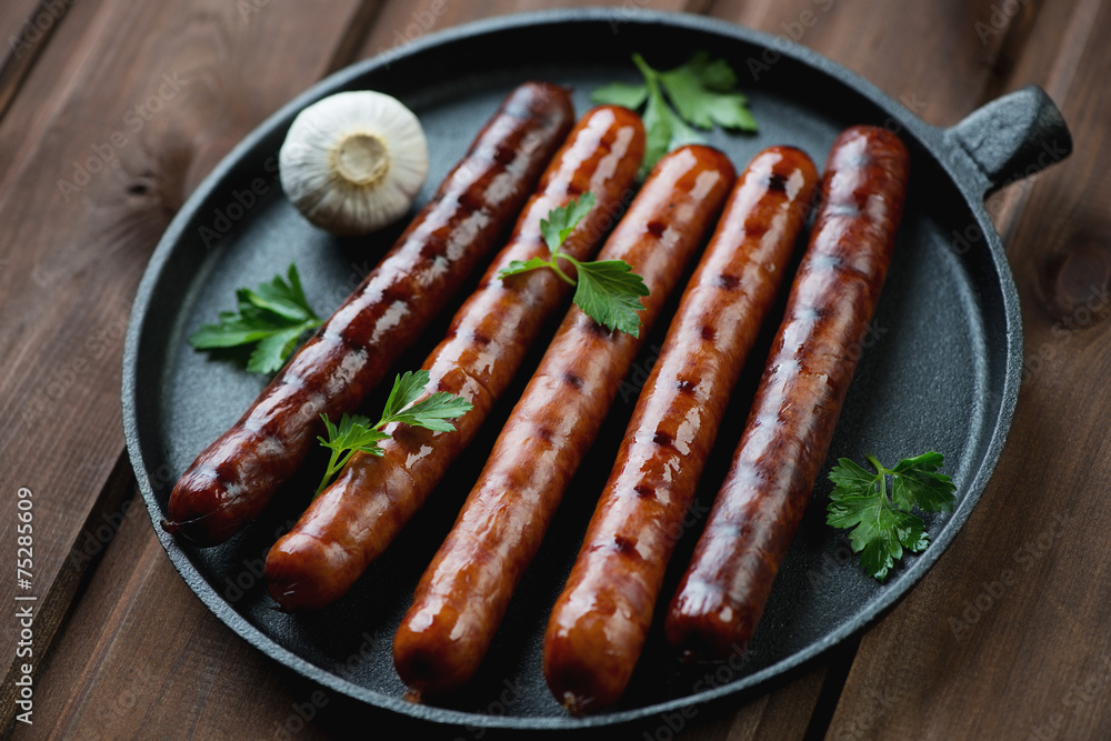 Grilled sausages with parsley and garlic in a frying pan Grilled sausages with parsley and garlic in a frying pan
