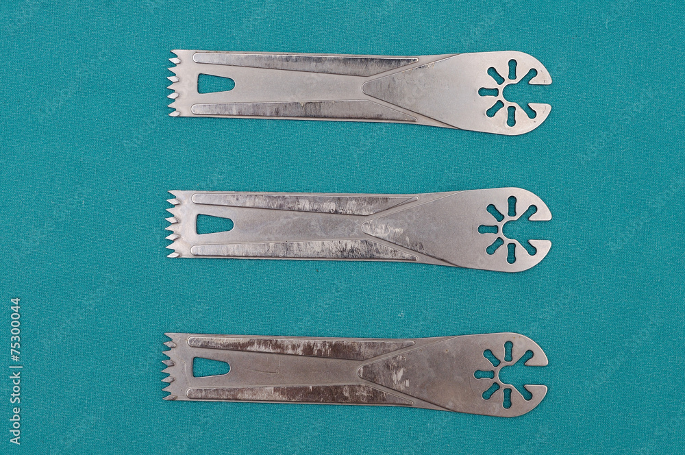 Wall Mural Surgery oscillating saw blades on green cloth.
