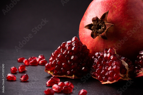 Some red pomegranates on black slate plate photo