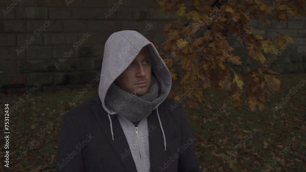 Man with hoodie standing on boulevard, steadycam, slow motion Man with hoodie standing on boulevard, steadycam, slow motion