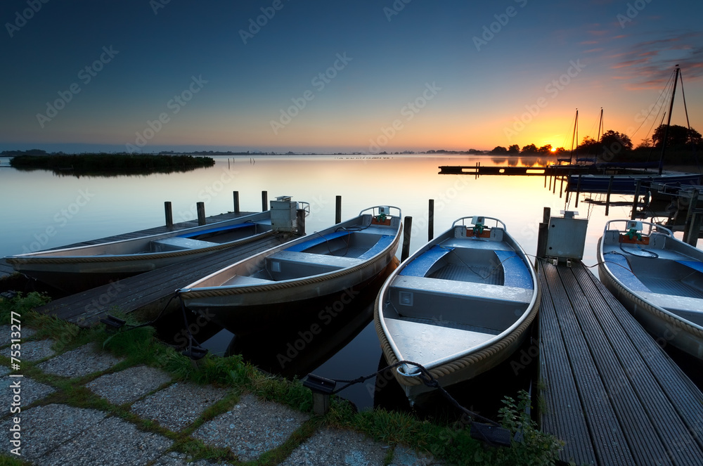 sunrise on lake harbor with boats