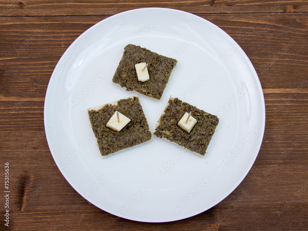 Canapes with olive paste on wooden table top views Canapes with olive paste on wooden table top views