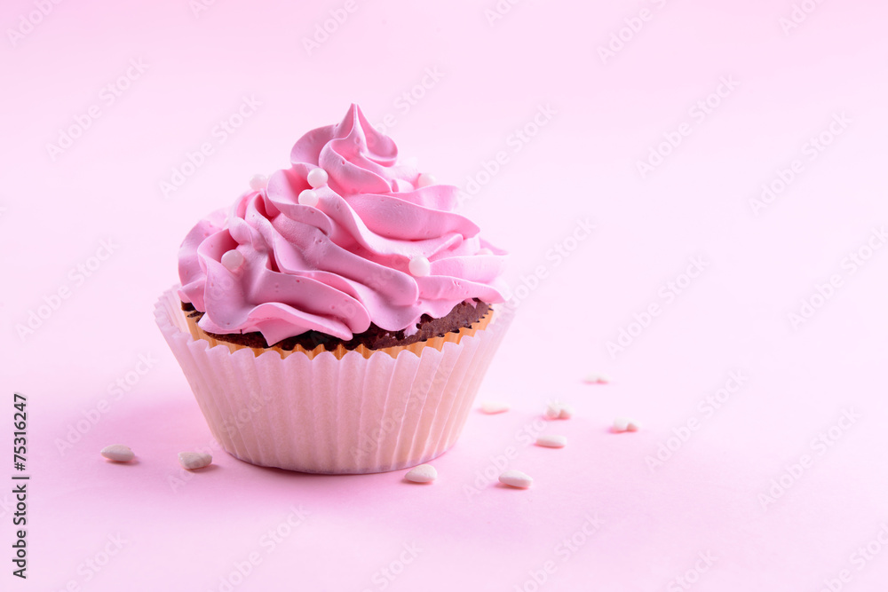 Delicious cupcake on pink background