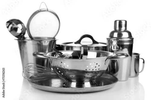 Stainless steel kitchenware on table, isolated on white