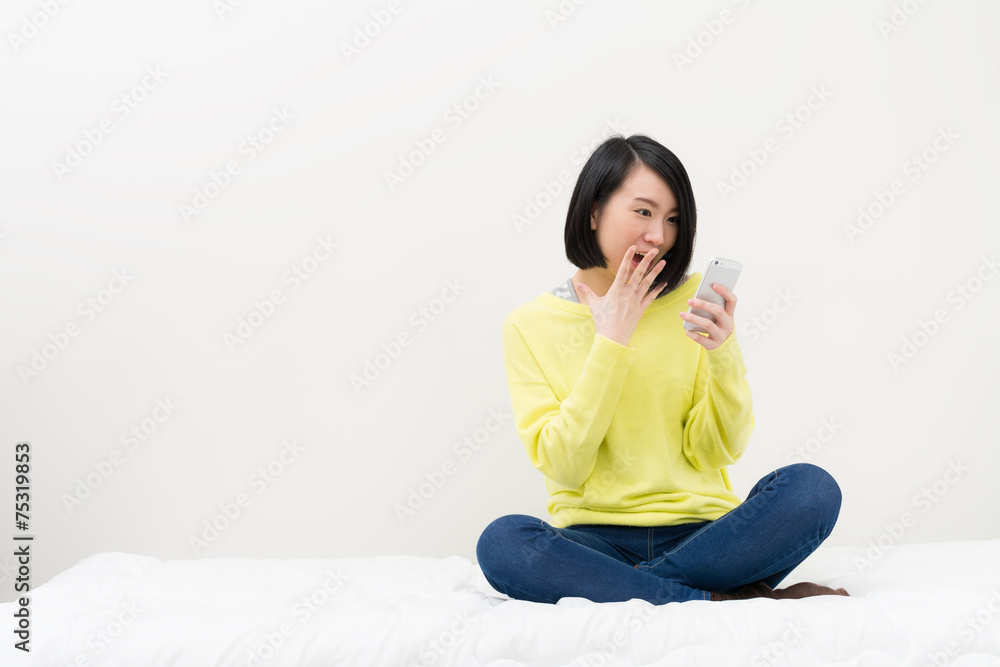 スマートフォンを見て喜ぶ女性