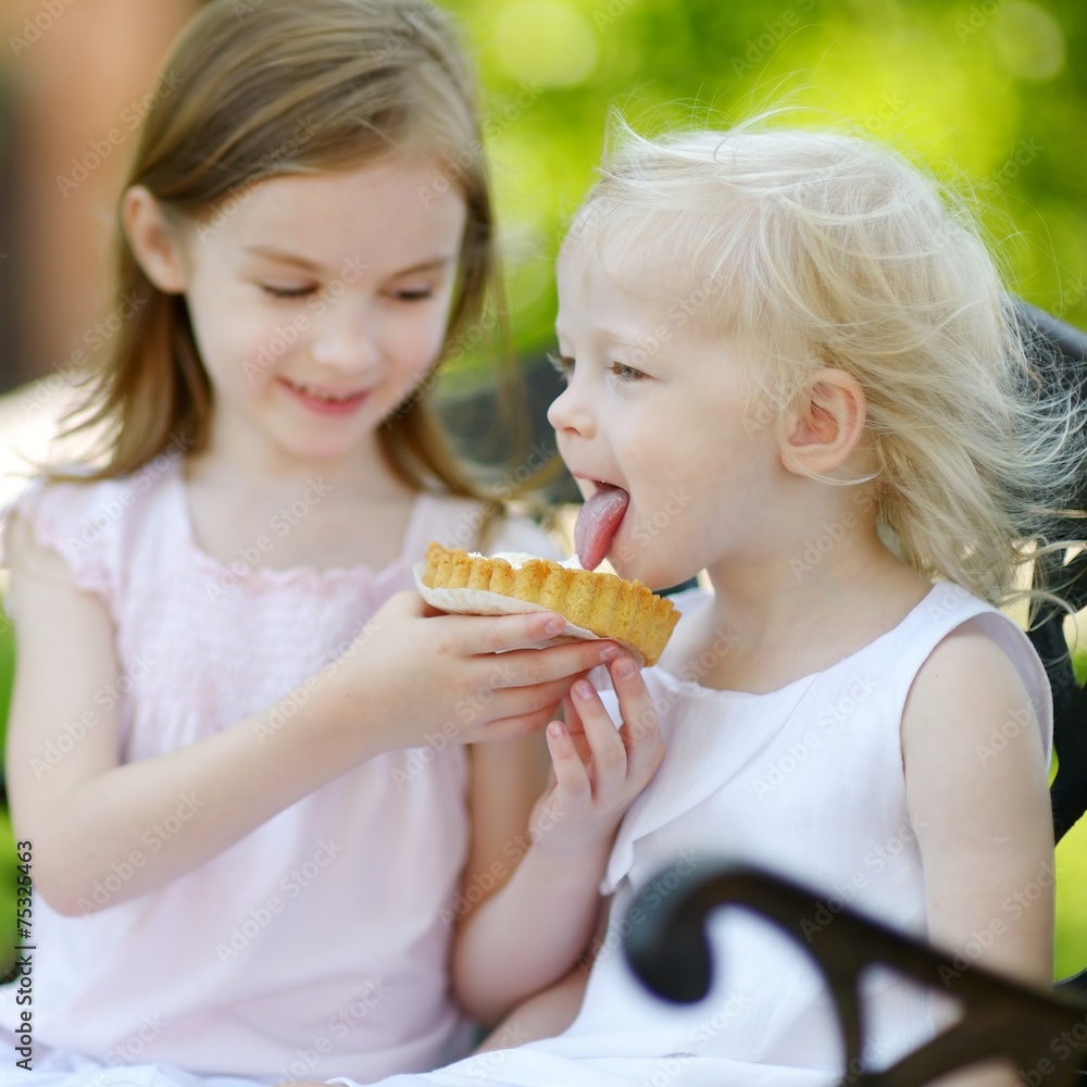 Two little sisters sharing delicious cream tart Two little sisters sharing delicious cream tart