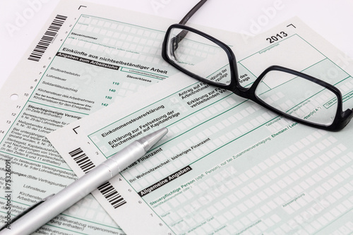 Formular Einkommensteuererkl  rung mit Kugelschreiber und Brille
