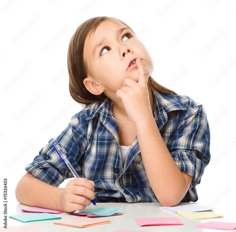 Girl is writing on color stickers using pen Girl is writing on color stickers using pen