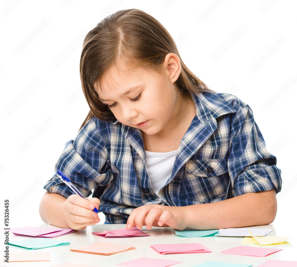 Girl is writing on color stickers using pen Girl is writing on color stickers using pen