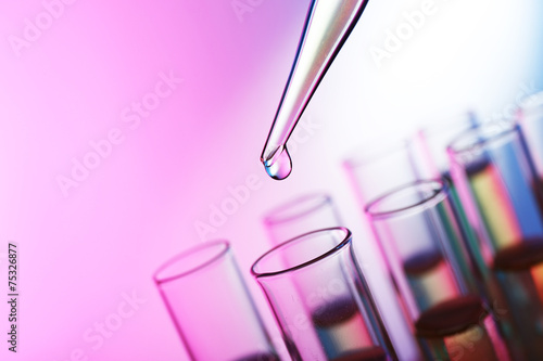 Pipette adding liquid to the one of test-tubes