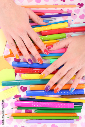 Multicolor female manicure with markers and pencils