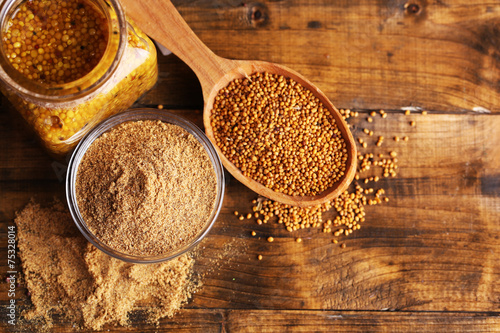 Mustard seeds, powder and sauce in glass jar, bowl and wooden photo