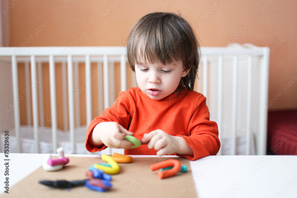 Lovely little boy playing with plasticine at home Lovely little boy playing with plasticine at home