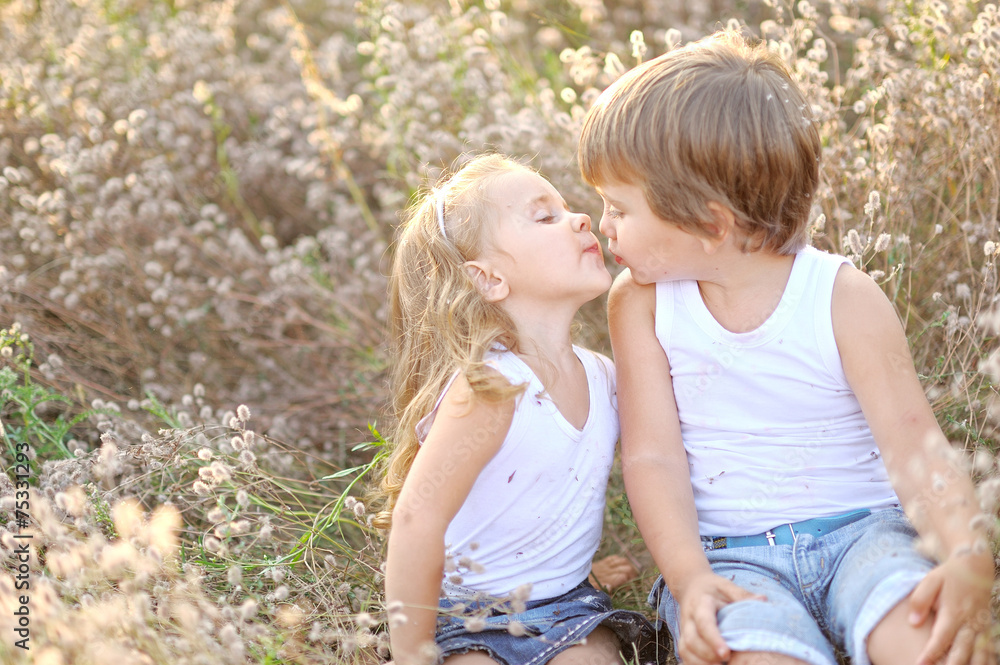 Portrait of a boy and girl on the field in summer Portrait of a boy and girl on the field in summer