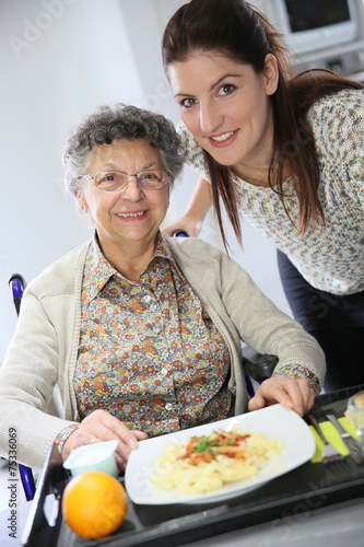 Homecarer preparing lunch for elderly woman