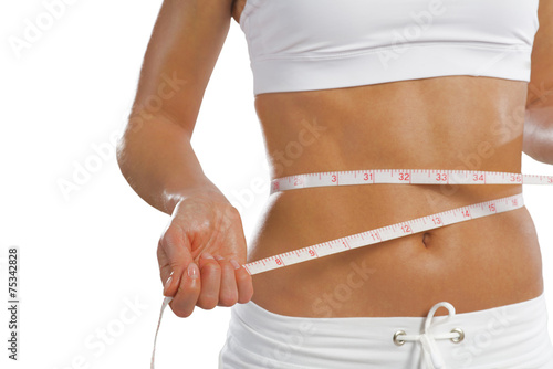 young athletic woman measuring waist