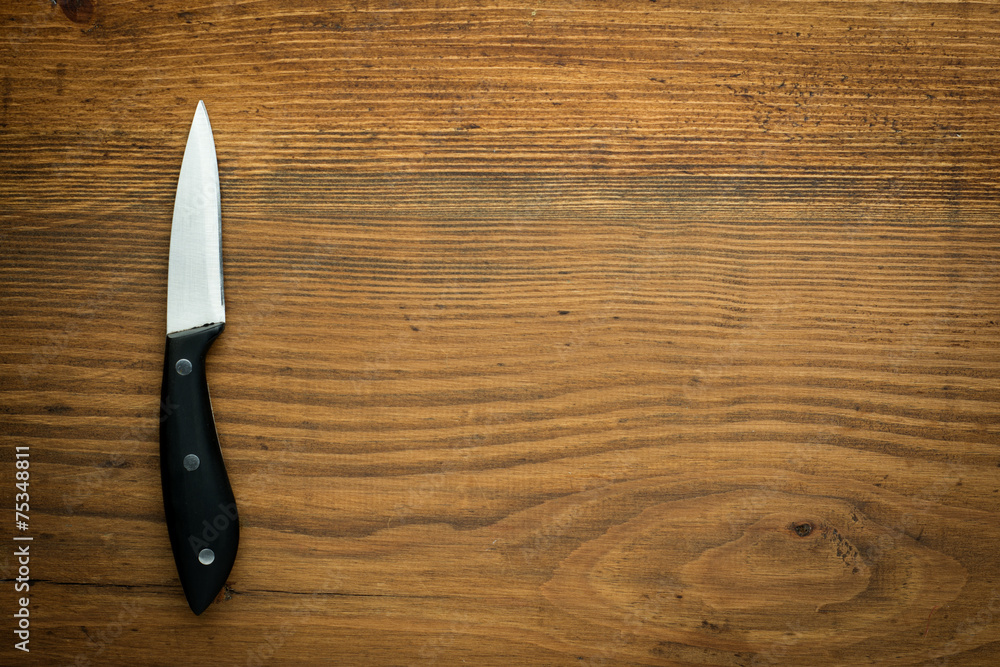 kitchen knife over brown wooden table