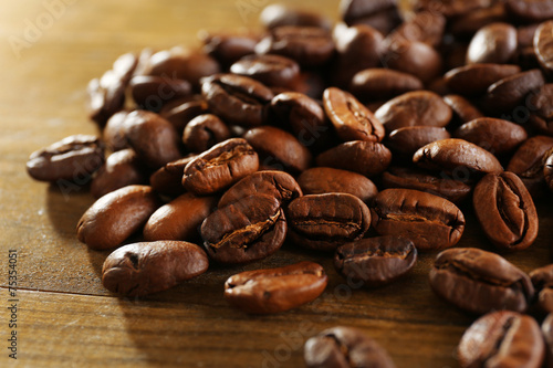 Coffee beans on wooden background, close-up