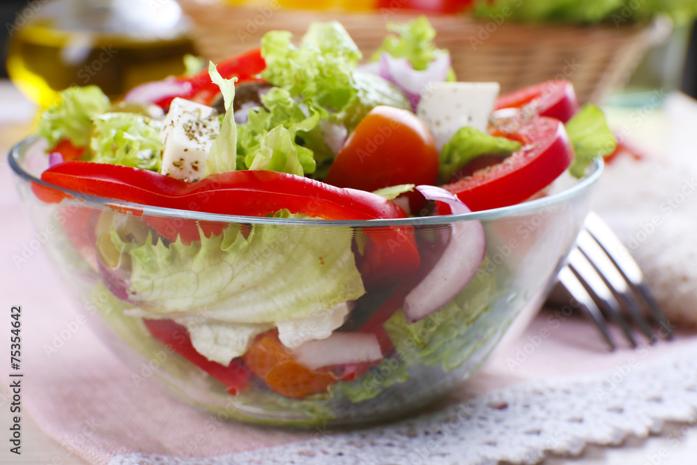 Greek salad in glass dish on napkin with fork, closeup Greek salad in glass dish on napkin with fork, closeup