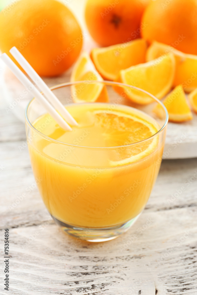 Glass of orange juice with straw and slices