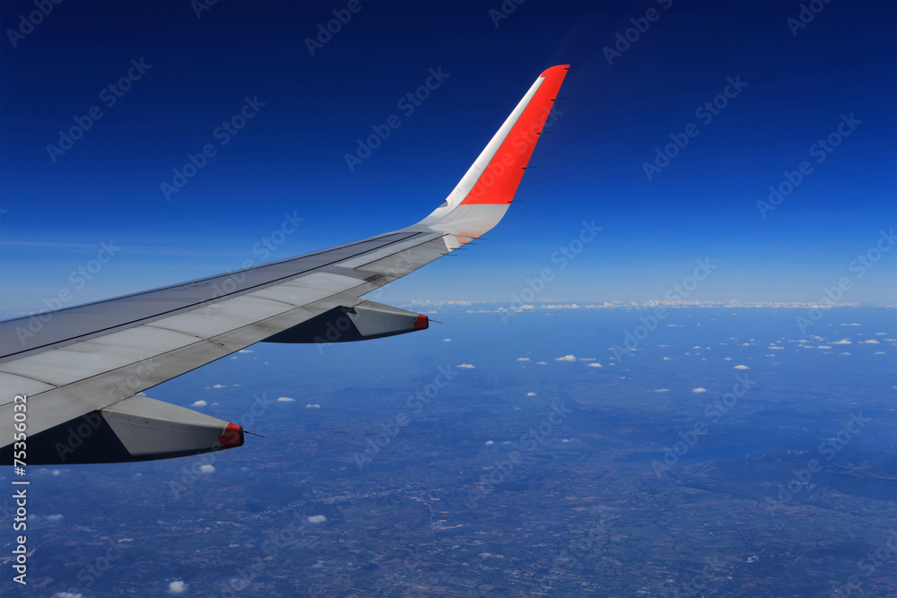 Wing of an airplane flying above the clouds Wing of an airplane flying above the clouds