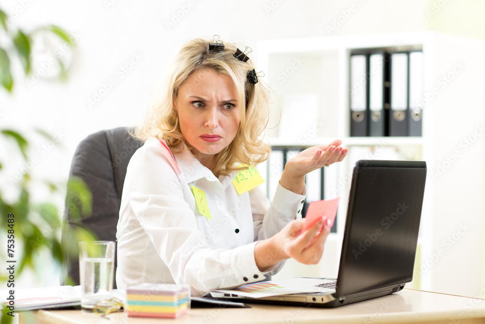 Stressed overworked businesswoman sitting at desk in office and Stressed overworked businesswoman sitting at desk in office and