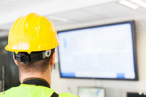 worker man looking at big plasma panel on wall