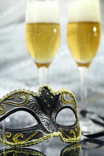 Vintage carnival mask in front of champagne glasses