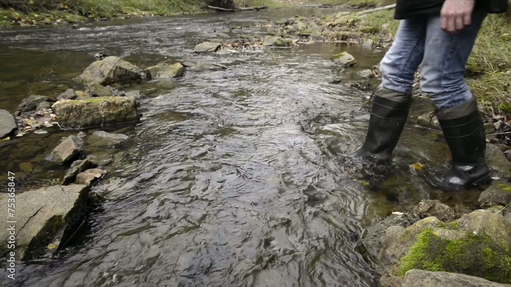 fisherman walking in the river stream fisherman walking in the river stream