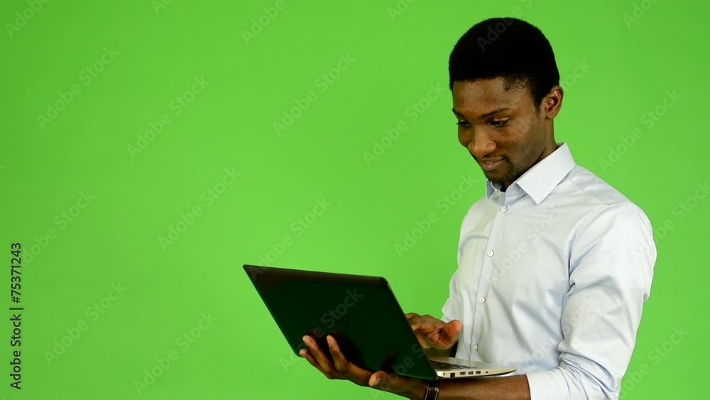 black man works on notebook and smiles - green screen - studio black man works on notebook and smiles - green screen - studio
